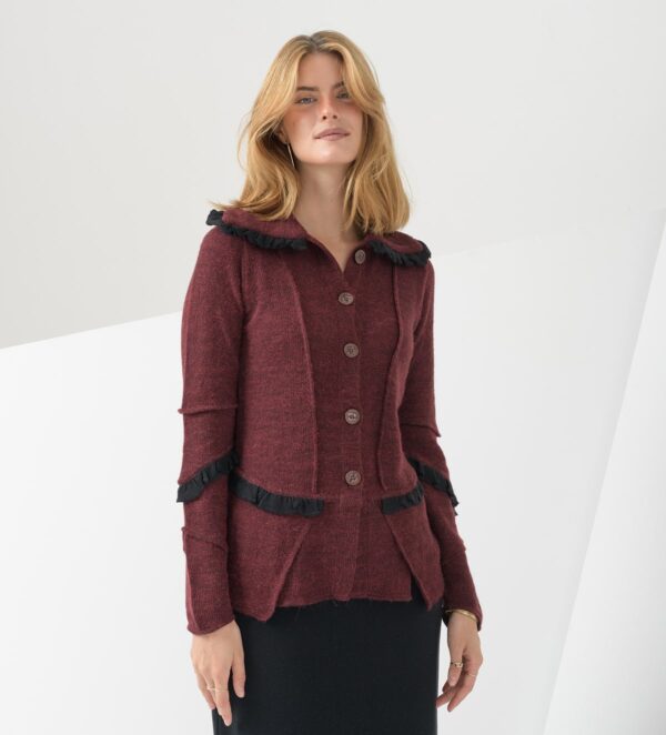 Modna jopica fantazijskega kroja, ki spominja na blazer se ponaša z vstavki iz gladke pletenine, z zanimivim ovratnikom, ter z zapenjanjem na gumbe.