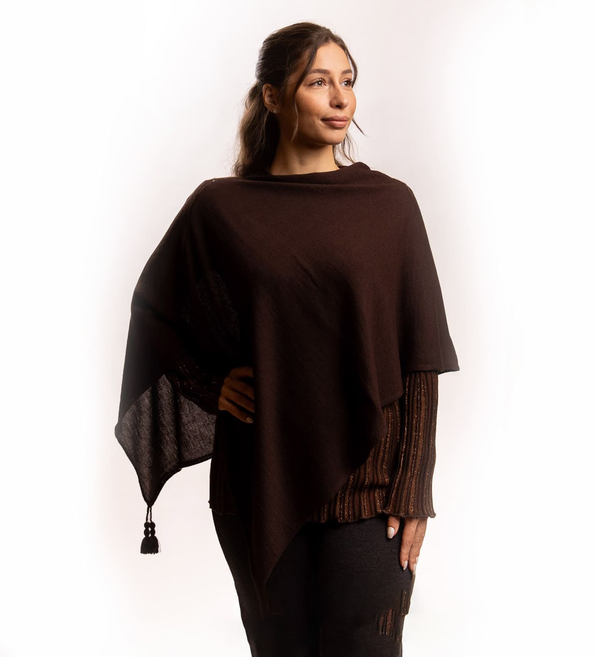 Tanek volnen pončo gladkega pletenja z okrasnimi cofki pri straneh. Pončo je zelo uporaben, saj ga lahko v hladnejših dneh uporabimo tudi namesto šala.