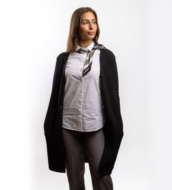 Eine lange Wolljacke mit V-Ausschnitt, die Wärme und Eleganz vereint. Sie ist mit praktischen Taschen und einem klassischen Knopfverschluss ausgestattet, was ihr Funktionalität und einen zeitlosen Look verleiht. Durch ihre Länge und den geraden Schnitt passt sie sowohl zu Hosen als auch zu Röcken und ist damit die ideale Wahl für den Alltag oder besondere Anlässe.