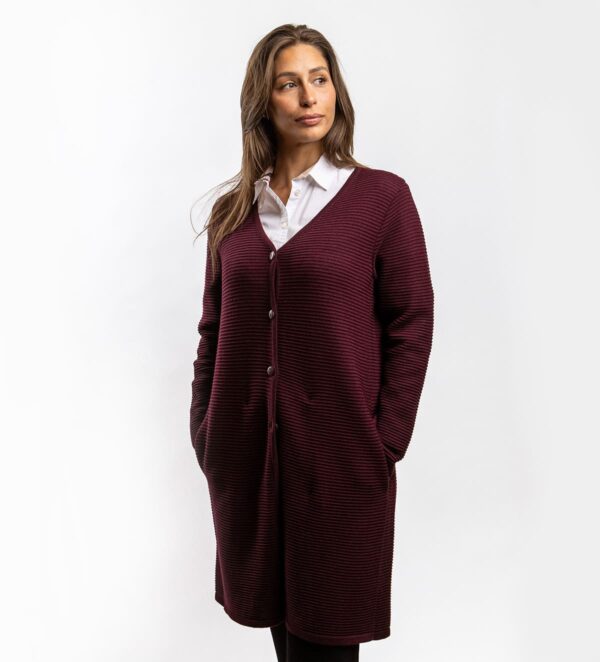 Eine lange Wolljacke mit V-Ausschnitt, die Wärme und Eleganz vereint. Sie ist mit praktischen Taschen und einem klassischen Knopfverschluss ausgestattet, was ihr Funktionalität und einen zeitlosen Look verleiht. Durch ihre Länge und den geraden Schnitt passt sie sowohl zu Hosen als auch zu Röcken und ist damit die ideale Wahl für den Alltag oder besondere Anlässe.