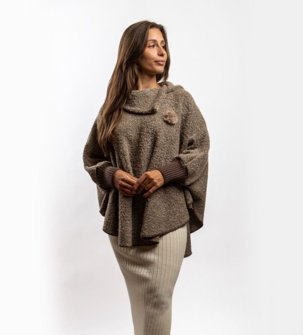 Der Poncho Bukle ist ein Wollponcho mit Ärmeln aus modischem Bouclé-Strick, der einfach über den Kopf gezogen wird. Er ist weich und bequem, bietet Wärme und Funktionalität und verleiht zugleich einen modernen und individuellen Look. Ideal für kühle Tage, lässt er sich sowohl im Alltag als auch zu besonderen Anlässen vielseitig kombinieren.