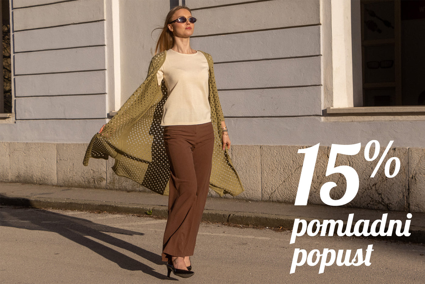 Ženska v elegantni pomladni opravi hodi po ulici. Pletenine Špenko ponujajo 15 % popust s kuponsko kodo POMLAD15. Popust velja ob nakupu nad 50 € do 19. 4.
