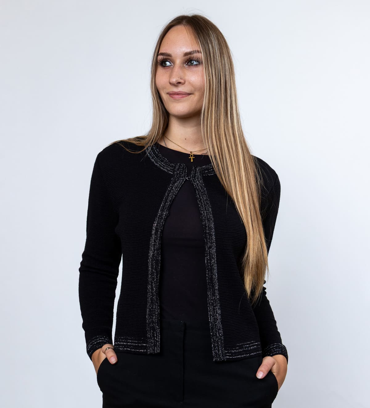 Ženska pletena jopica Talia je elegantna in lahkotna izbira za urejen videz. Tanka volnena pletenina je ob robovih okrašena z bleščečimi nitkami, ki jopici dodajo čudovit lesk.
