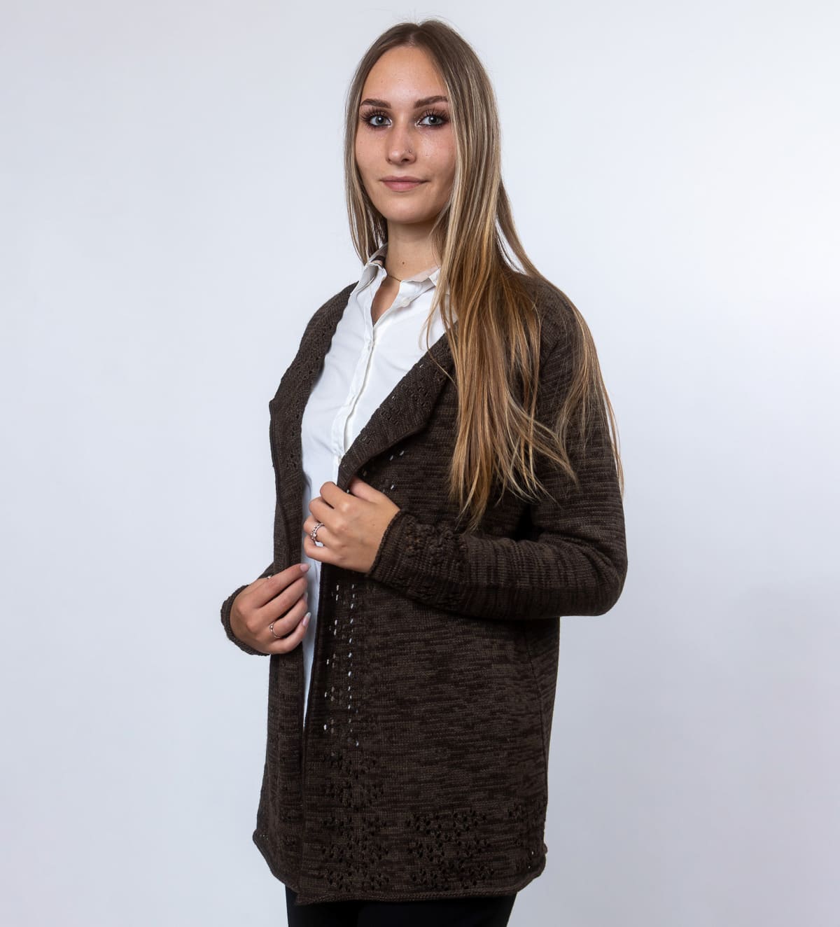 Elegantna volnena jopica Tiffany iz melirane pletenine z nežnimi luknjicami na sprednjem delu in spodnjem robu. Poseben vzorec ji daje ženstven in prefinjen videz.
