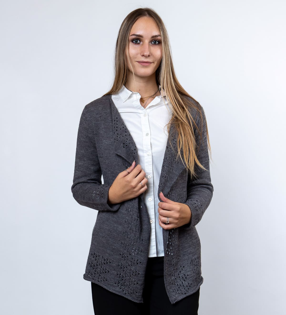 Elegantna volnena jopica Tiffany iz melirane pletenine z nežnimi luknjicami na sprednjem delu in spodnjem robu. Poseben vzorec ji daje ženstven in prefinjen videz.