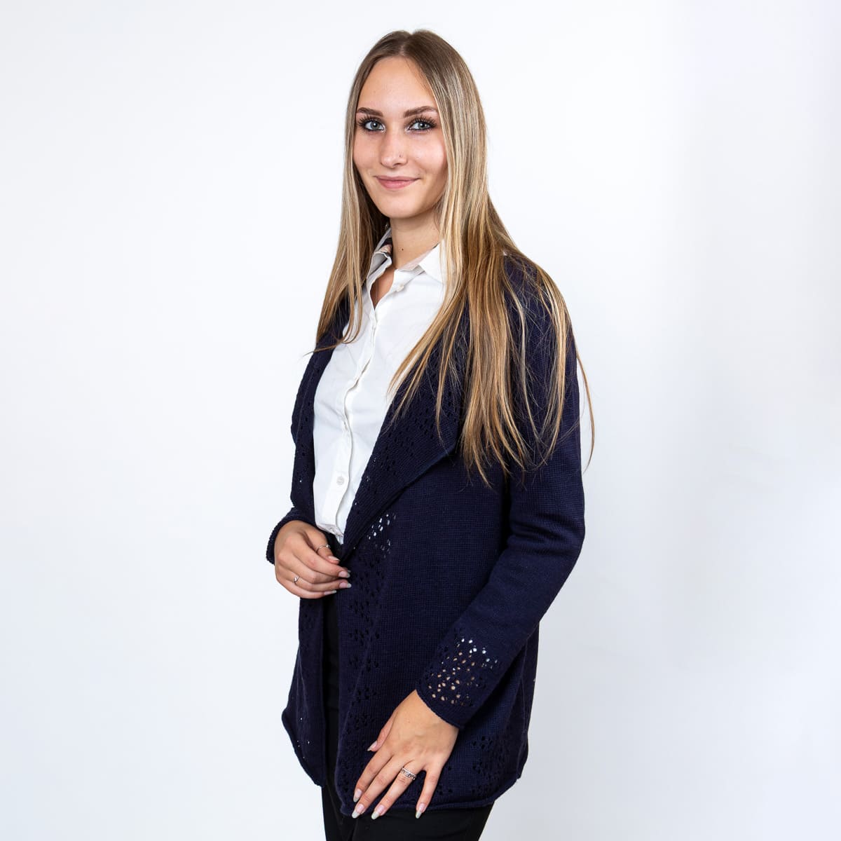 Elegantna volnena jopica Tiffany iz melirane pletenine z nežnimi luknjicami na sprednjem delu in spodnjem robu. Poseben vzorec ji daje ženstven in prefinjen videz.