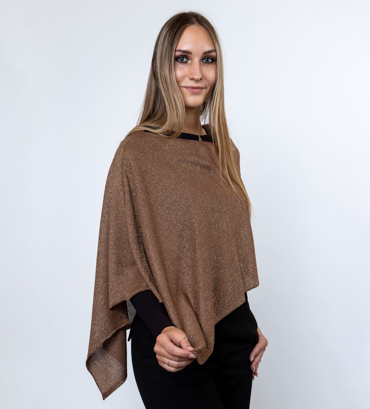 Ženski pončo Talia je lahek in eleganten kos iz tanke pletenine, ki ga popestrijo nežne svetleče nitke. Subtilen sijaj mu daje prefinjen in ženstven videz.